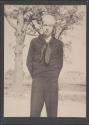 [Sailor in Navy uniform standing by tree]