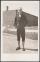 [Sailor in Navy uniform with puttees standing in dirt road]