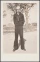 [Sailor in Navy uniform standing by tree]