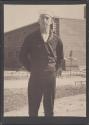 [Sailor in Navy uniform standing in dirt road]