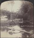 [Bridge and buildings by a creek]