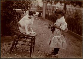 [Child taking photograph of dog]