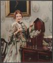 [Woman looking at silverware (International Silver)]