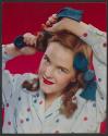 [Girl in polka dot pajamas using rag curlers (McCall's)]