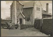 Johnsons beside house and automobile, African Safari