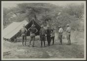 Group looking at panoramic photo set up under tent, African Safari