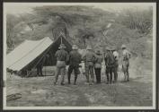 Group looking at panoramic photo set up under tent, African Safari