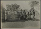 George Eastman and native men beside Kodok sign, African Safari