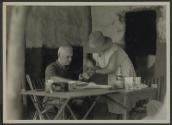 George Eastman and unidentified woman at desk, African Safari
