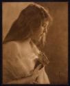 [Woman holding flower]