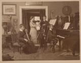 [Children playing instruments in parlor]