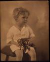 [Child holding toy elephant]