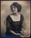 [Woman holding feather fan]