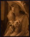 [Woman in hat with flowers]