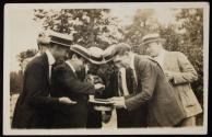 [Elias Goldensky and others gathered around hat]