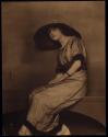 [Seated woman in hat]