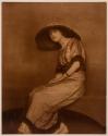 [Seated woman in large hat]