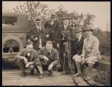 [Elias Goldensky (second on left), standing on a bridge with six other men, some holding cameras]