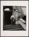 [Man on stoop of rooming house]