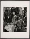[Young woman and child watching a parade]