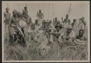 Companions and native tribesmen with dead lion, African Safari