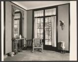 [Interior with armchair, French window, mirror, and sculptural objects]