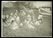 [A group of men cooking on a beach]