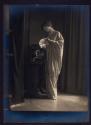 [Standing woman holding fan]