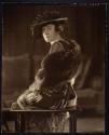 [Seated woman wearing hat and fur stole]