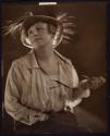 [Seated woman in hat]