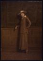 [Standing woman wearing hat]