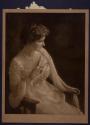 [Woman holding fan]
