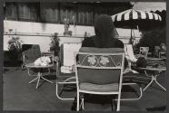 [Woman sitting outdoors with back turned]