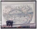 [Miguel Covarrubias with two individuals standing in front of his mural "Flora and Fauna" ]