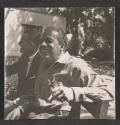 [Two men seated on bench]