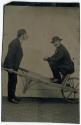 [Trick photo of man pushing himself in a wheelbarrow]
