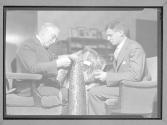 [Two Men Inspecting Fabric]