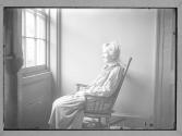 Old Woman in Rocking Chair looking out the window