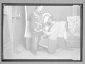 [Woman helping boy scout with indian costume]