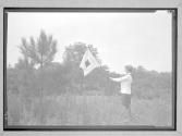 [Girl Scout with flags in field]