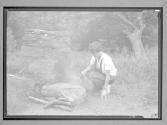 [Girl Scout near outdoor fireplace]