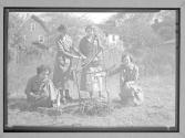 [Woman making fire outside]