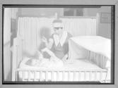 [Nurse with Baby in Crib]