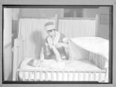 [Nurse with Baby in Crib]