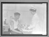 Nurse and Patient in Dispensary in Large Factory