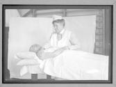 Nurse Exercising Arm Of Injured Man In Dispensary (Chicago Slum)