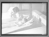 [Woman Lowering Child into Therapy Bath]