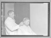 [Man Cutting Older Man's Hair]