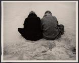[Two men sitting on beach]