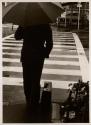 [Man with umbrella and briefcase, Japan]